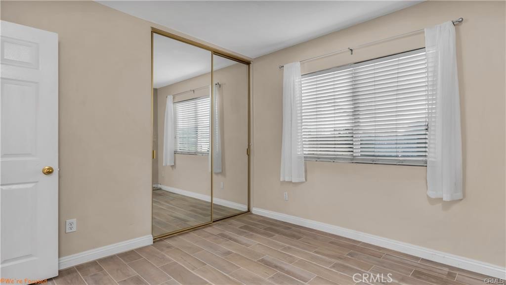 16661 Carousel Lane Huntington Beach, CA 92649 - Photo 25 of 47 a view of an empty room with wooden floor and a window