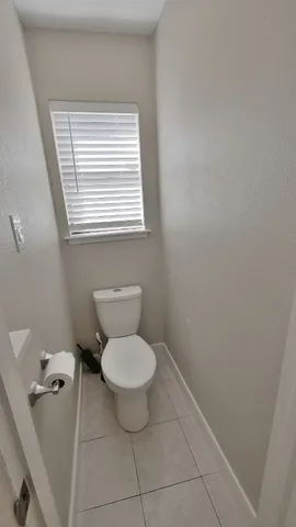 a bathroom with a toilet and a window