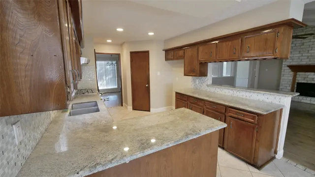 a kitchen with kitchen island a sink and wooden cabinets