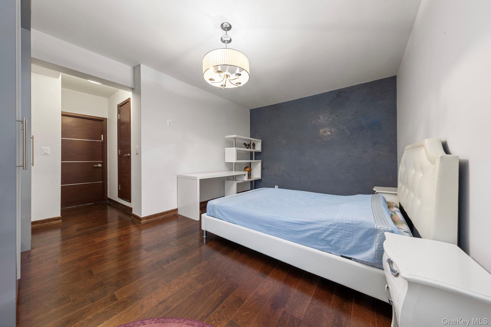 99-72 66th Road, Unit 1Z Queens, NY 11374 - Photo 11 of 16 a bedroom with a bed and a chandelier