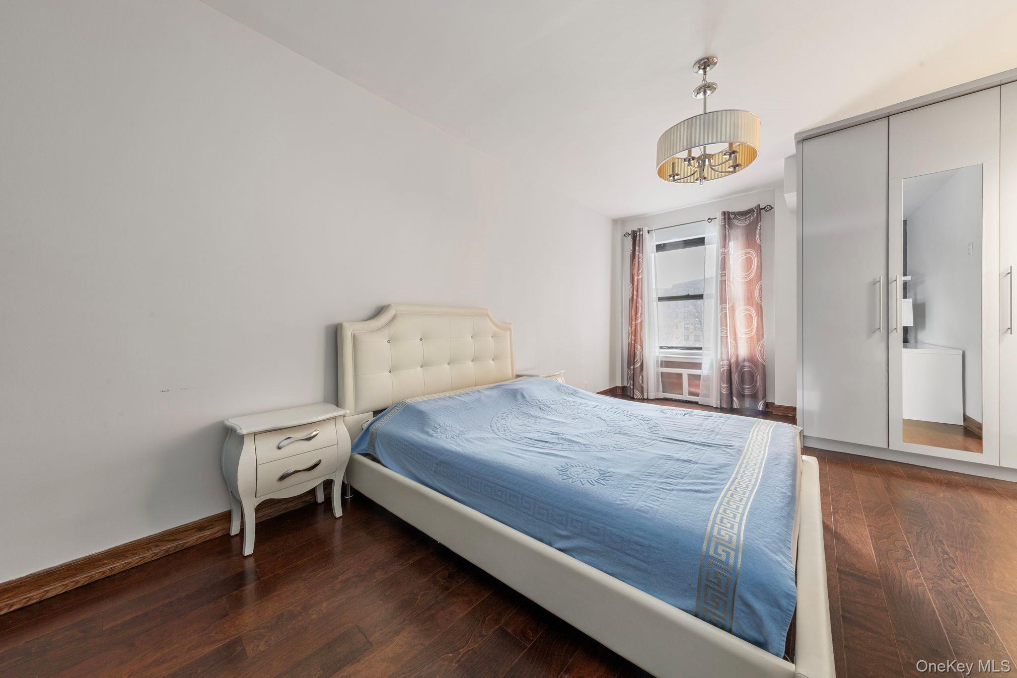 99-72 66th Road, Unit 1Z Queens, NY 11374 - Photo 12 of 16 a bedroom with a bed and a table with wooden floor