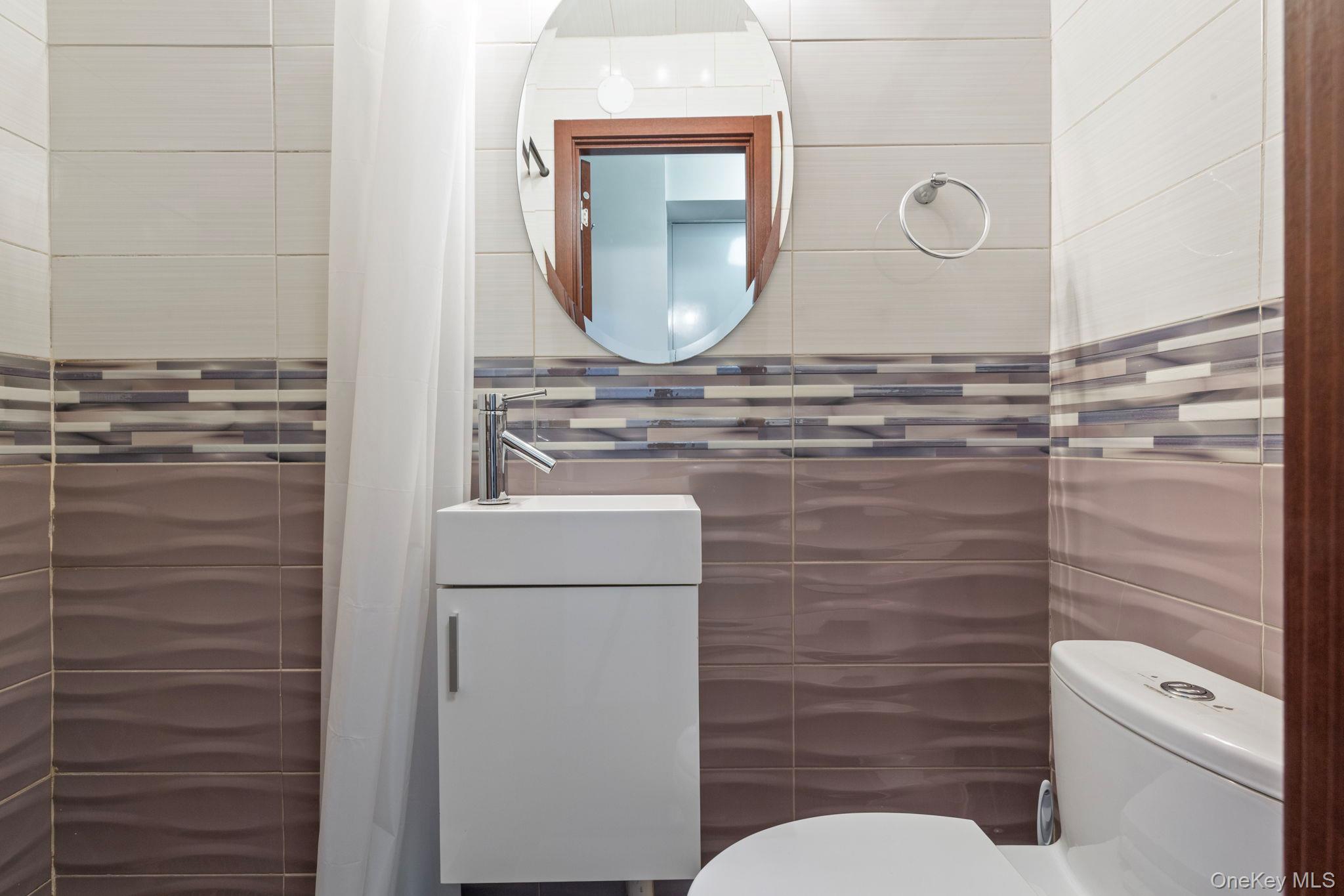 99-72 66th Road, Unit 1Z Queens, NY 11374 - Photo 13 of 16 a bathroom with a toilet a sink and a mirror