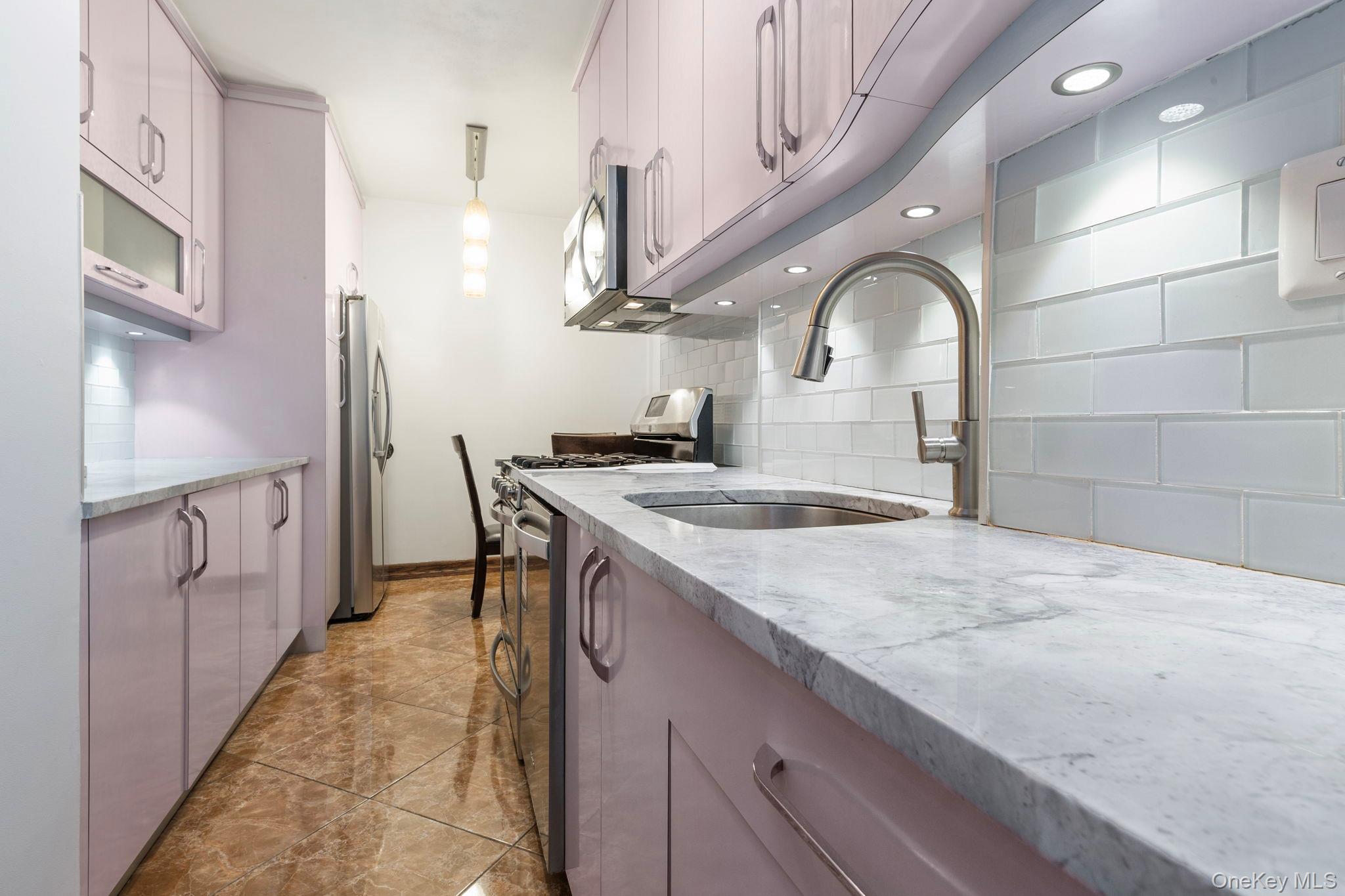 99-72 66th Road, Unit 1Z Queens, NY 11374 - Photo 4 of 16 a kitchen with stainless steel appliances granite countertop a sink stove and cabinets