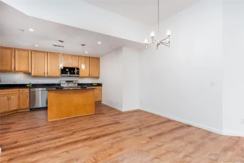 a kitchen with stainless steel appliances hardwood floor sink and cabinets