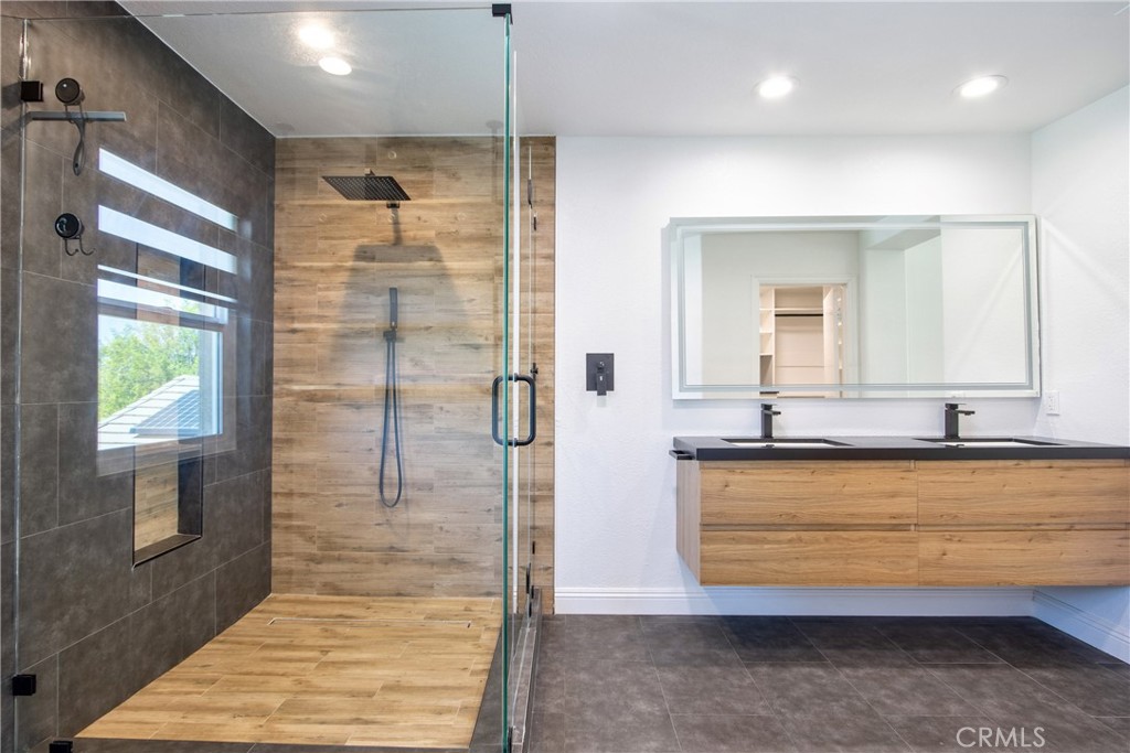 23126 Teil Glen Road Wildomar, CA 92595 - Photo 23 of 48 a bathroom with a granite countertop sink a mirror and shower