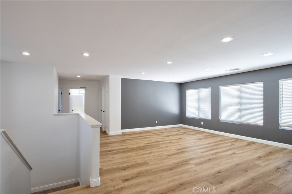 23126 Teil Glen Road Wildomar, CA 92595 - Photo 25 of 48 a view of an empty room with wooden floor and a window