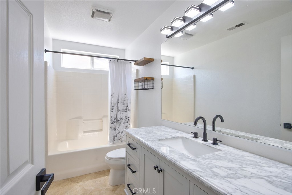 23126 Teil Glen Road Wildomar, CA 92595 - Photo 30 of 48 a bathroom with a granite countertop sink a toilet and shower