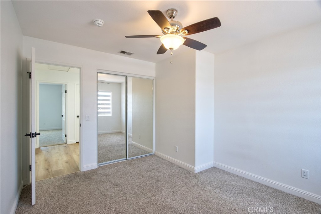 23126 Teil Glen Road Wildomar, CA 92595 - Photo 36 of 48 an empty room with closet and a chandelier fan