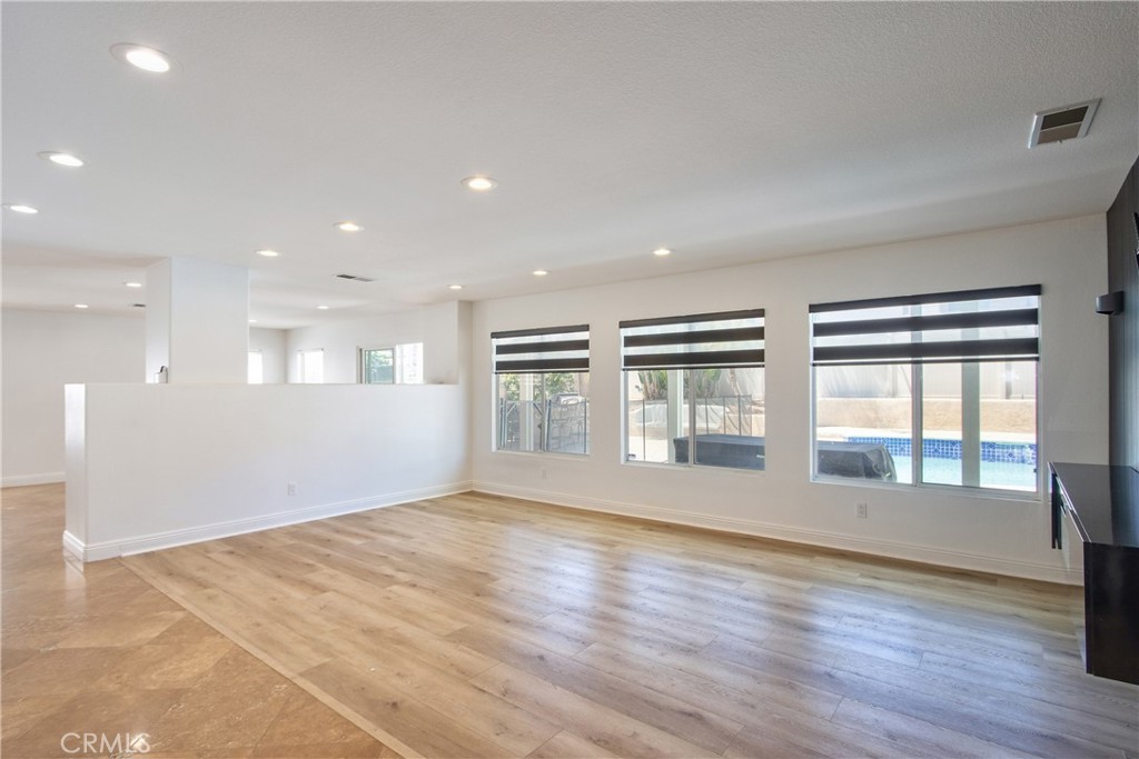 23126 Teil Glen Road Wildomar, CA 92595 - Photo 6 of 48 a view of an empty room with wooden floor and a window