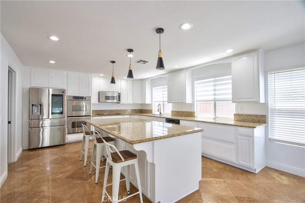 23126 Teil Glen Road Wildomar, CA 92595 - Photo 10 of 48 a kitchen with stainless steel appliances kitchen island granite countertop a sink and stove
