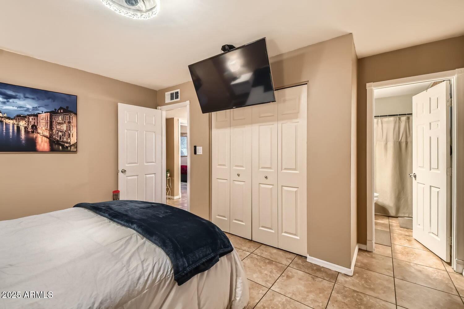 9031 North 14th Street Phoenix, AZ 85020 - Photo 13 of 33 a bedroom with a bed and a flat screen tv