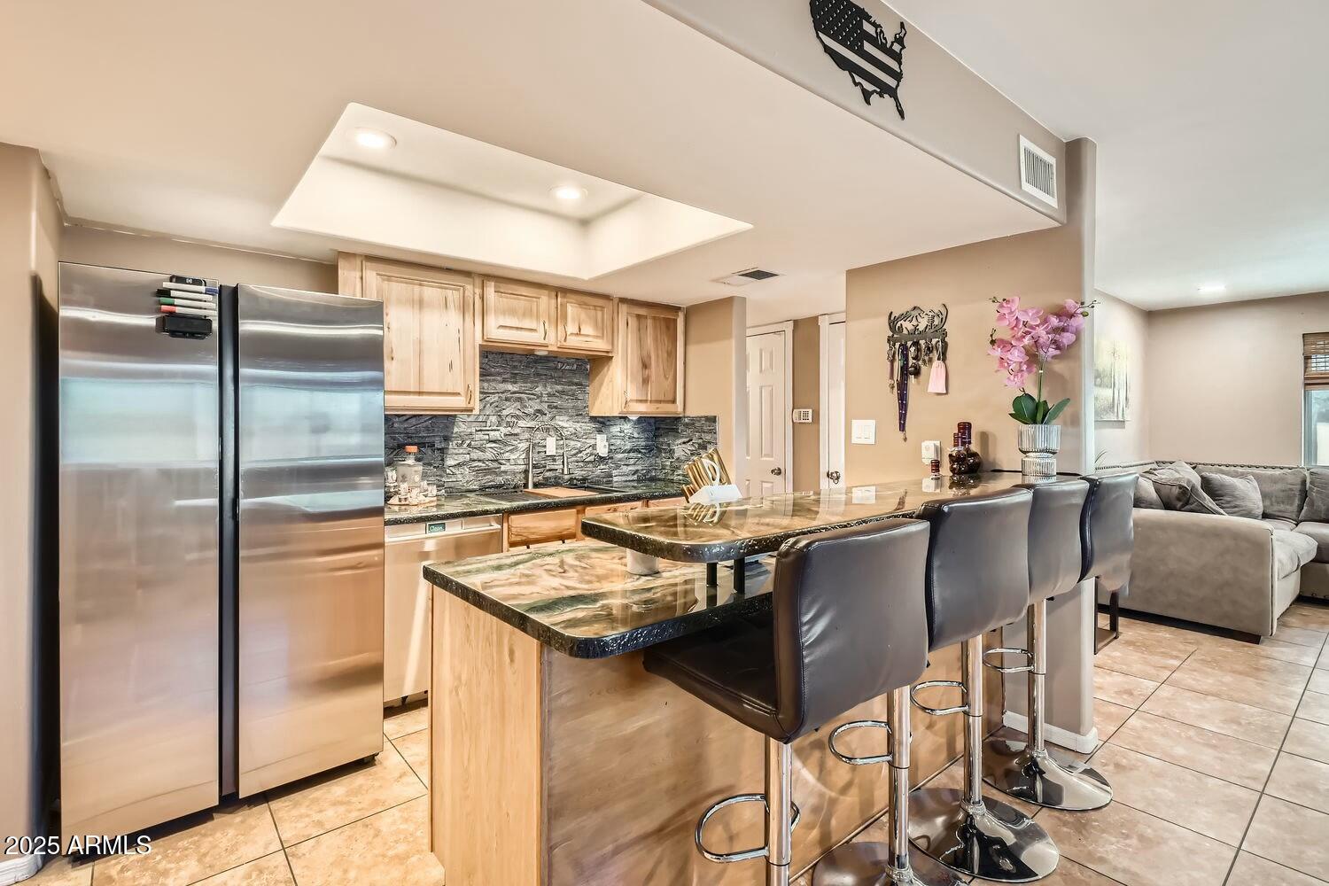 9031 North 14th Street Phoenix, AZ 85020 - Photo 7 of 33 a kitchen with granite countertop kitchen island stainless steel appliances a sink refrigerator and chairs