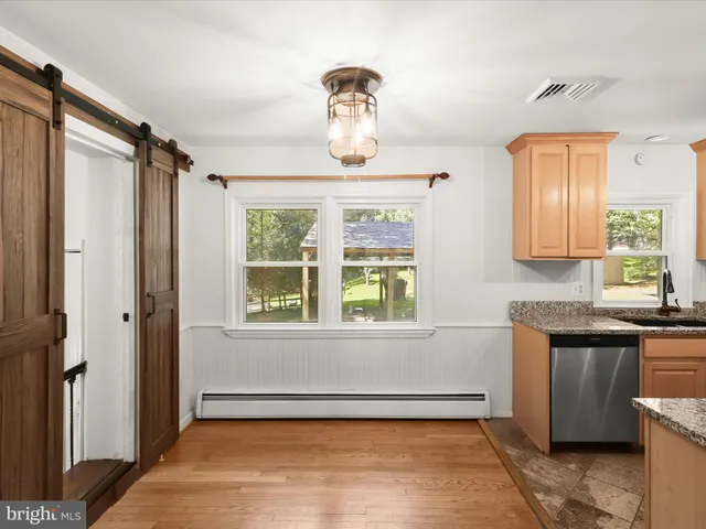a view of empty room with window and wooden floor