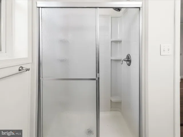 a bathroom with a granite countertop bathtub shower sink vanity and toilet