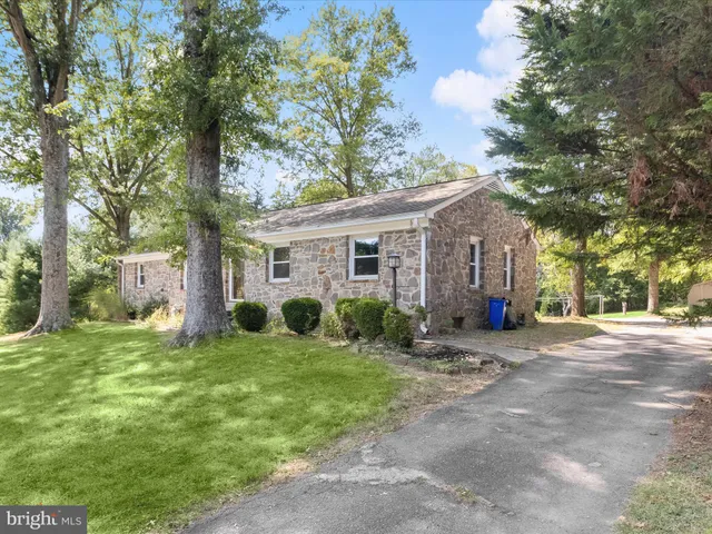 a view of a house with a yard and large tree