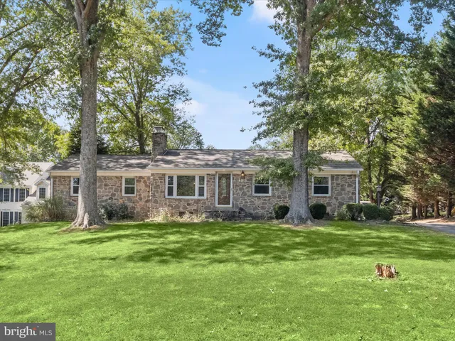 a view of a big house with a big yard and large trees