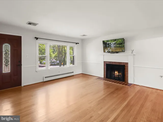wooden floor fireplace and windows in an empty room