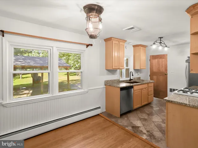 a kitchen with a stove a sink and a window