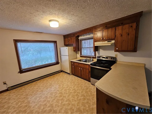 a kitchen with stainless steel appliances a stove refrigerator sink and cabinets