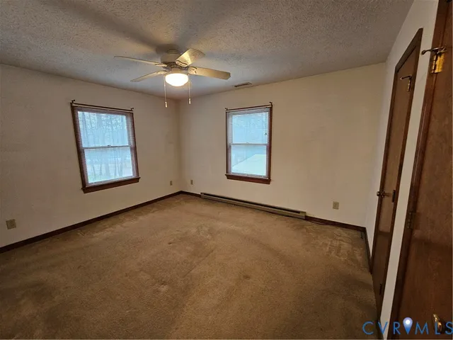 an empty room with windows and fan