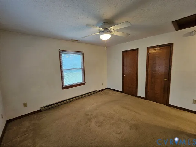 an empty room with windows and fan