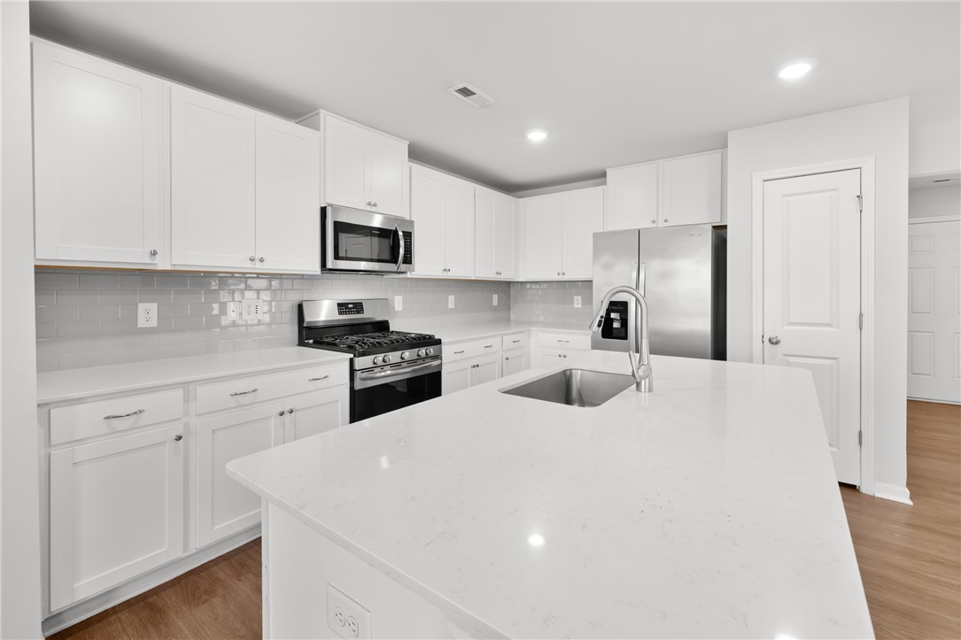 520 Brasstown Court Pendleton, SC 29670 - Photo 4 of 29 This modern kitchen features crisp white cabinetry, stainless steel appliances, and sleek countertops.