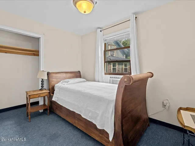 a bed sitting in a bedroom next to a window