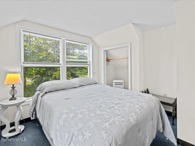 a large bed sitting in a bedroom next to a window