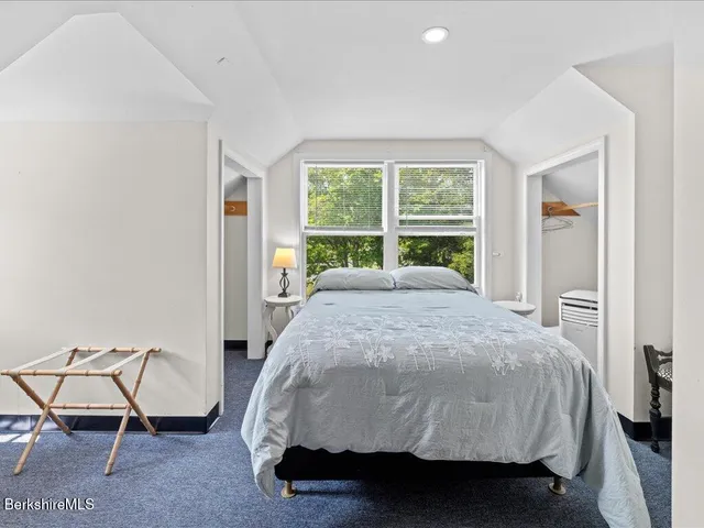 a bed sitting in a bedroom next to a window