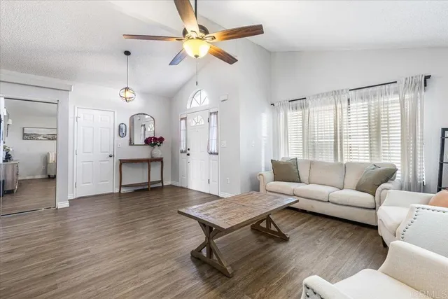 a living room with furniture a table and wooden floor