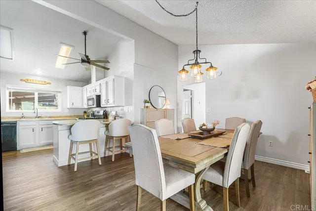 a dining room with furniture a chandelier and wooden floor