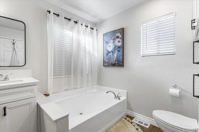 a bathroom with a sink a toilet and shower curtain