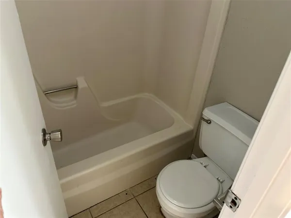 a white toilet sitting next to a bath tub