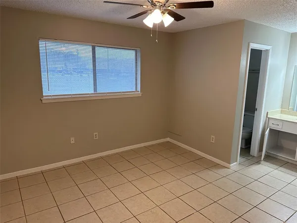 an empty room with chandelier fan