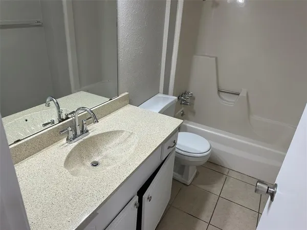 a bathroom with a granite countertop sink toilet and a mirror