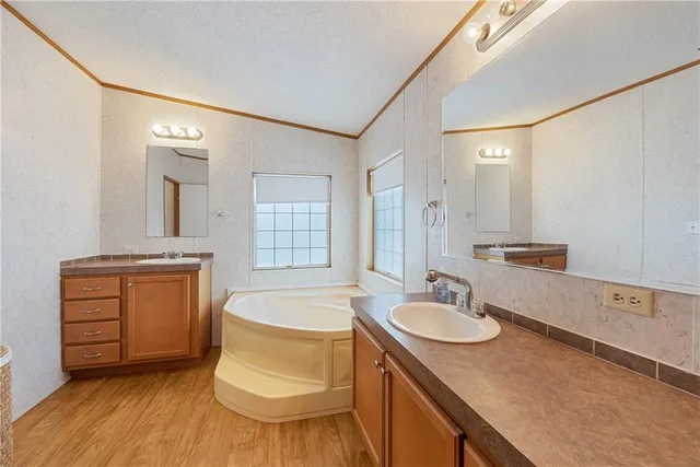 a bathroom with a granite countertop sink mirror and bathtub