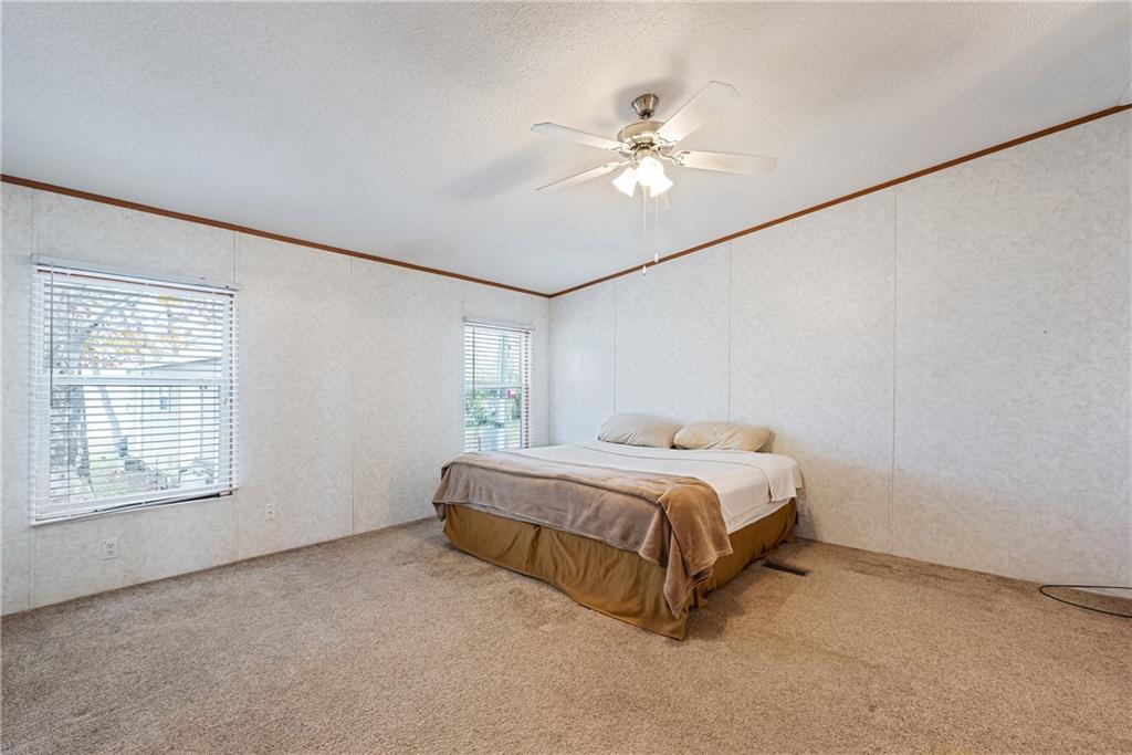 260 Lcr 751 Road Thornton, TX 76687 - Photo 20 of 40 a spacious bedroom with a bed and a chandelier