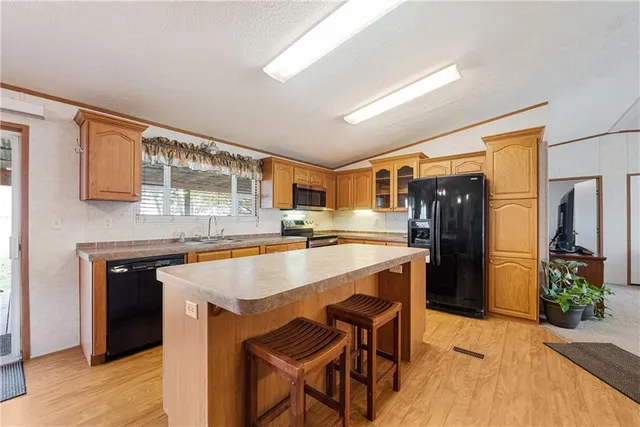 a kitchen with a table chairs refrigerator and cabinets