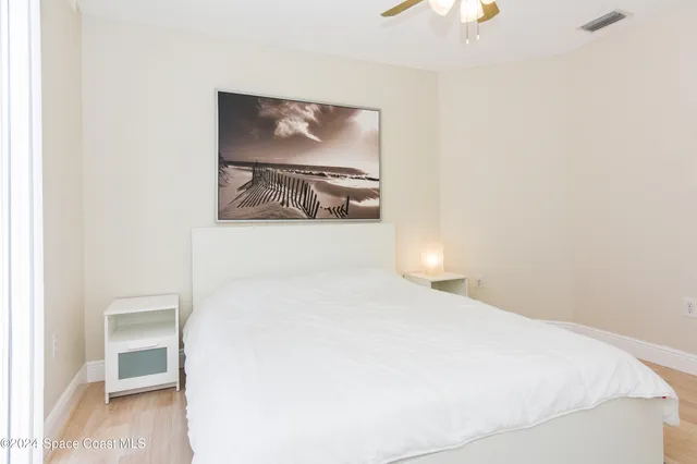 a bedroom with a bed and a painting on the wall