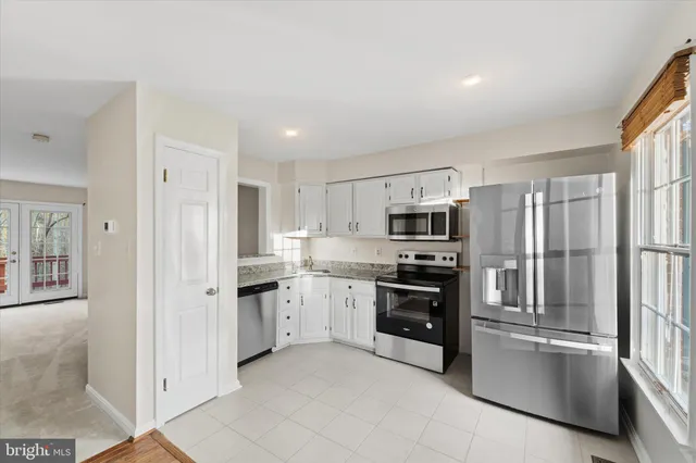 a kitchen with stainless steel appliances granite countertop a refrigerator and a stove top oven