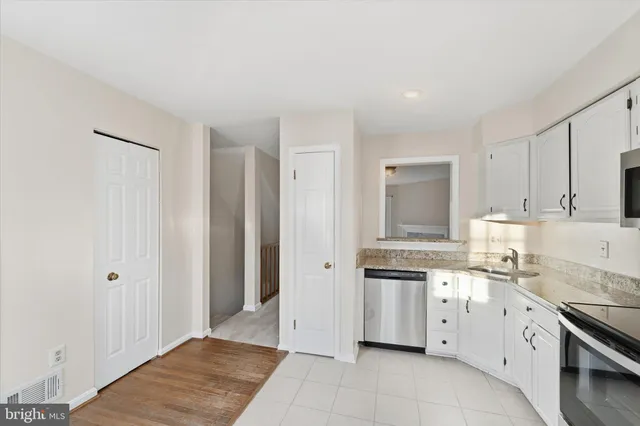 a view of a kitchen with white cabinets