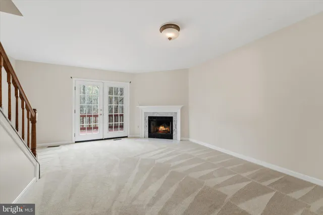 a view of an empty room with a fireplace and a window