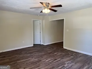 a view of an empty room with wooden floor
