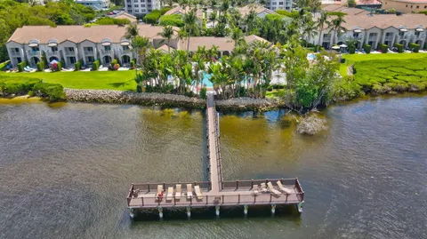 an aerial view of a house with a yard and lake view