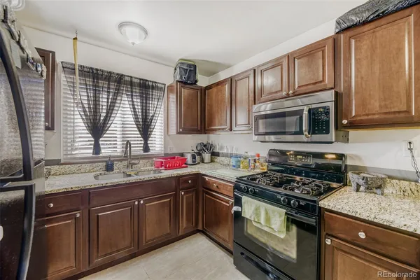 a kitchen with stainless steel appliances granite countertop a stove sink microwave and cabinets