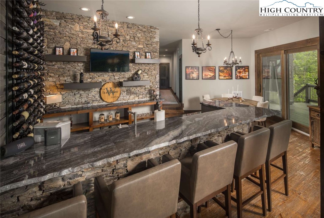 856 Ninebark Road Boone, NC 28607 - Photo 14 of 30 a kitchen with stainless steel appliances granite countertop a stove top oven a dining table and chairs with the floor to ceiling window