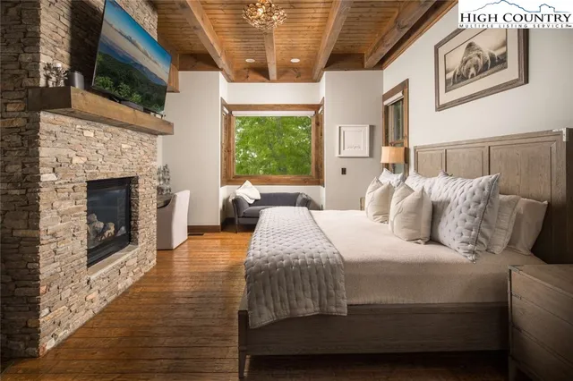 a bedroom with a bed a fireplace and window