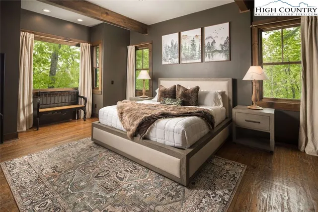 a bedroom with a bed wooden floor and window