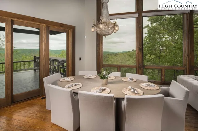 a dining room with furniture a chandelier and glass door