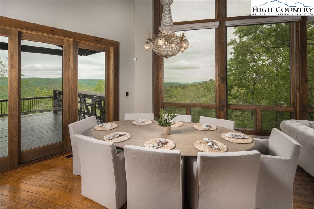 856 Ninebark Road Boone, NC 28607 - Photo 9 of 30 a dining room with furniture a chandelier and glass door
